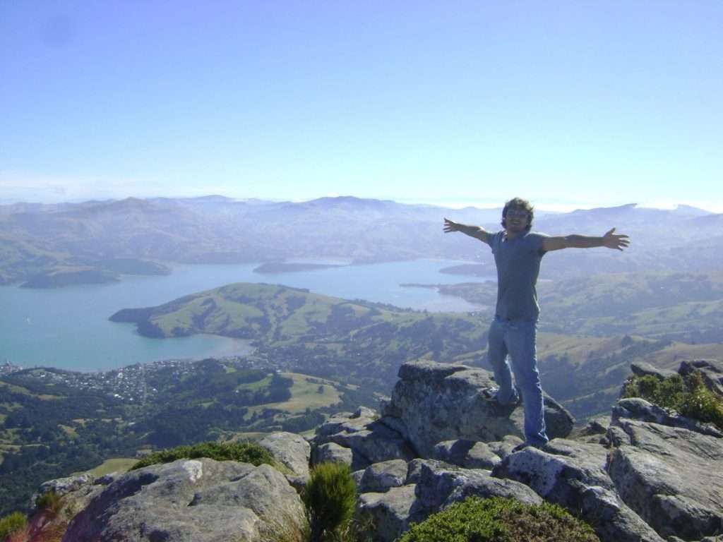 Man standing on top of Banks Peninsula summit experiencing freedom
